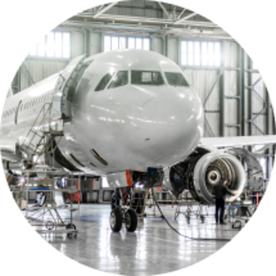 Passagierflugzeug in einem Hangar während der Wartung mit geöffnetem Triebwerk und Wartungsgerüsten.